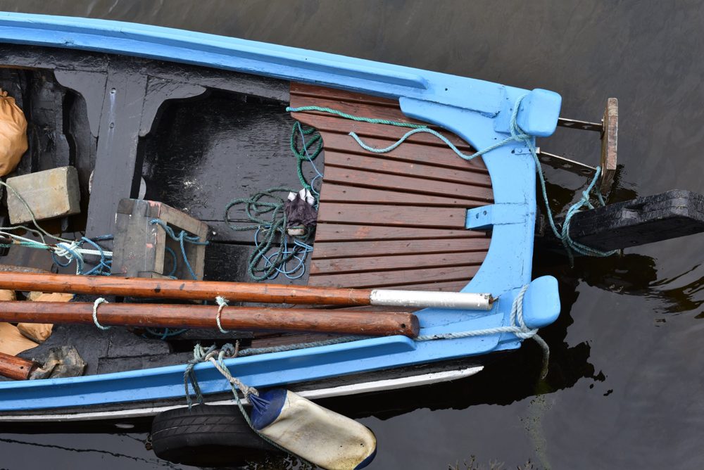 Blue Boat, Irish photography print: blue wooden boat seen from above on dark water, Ireland, by Dan O'Sullivan